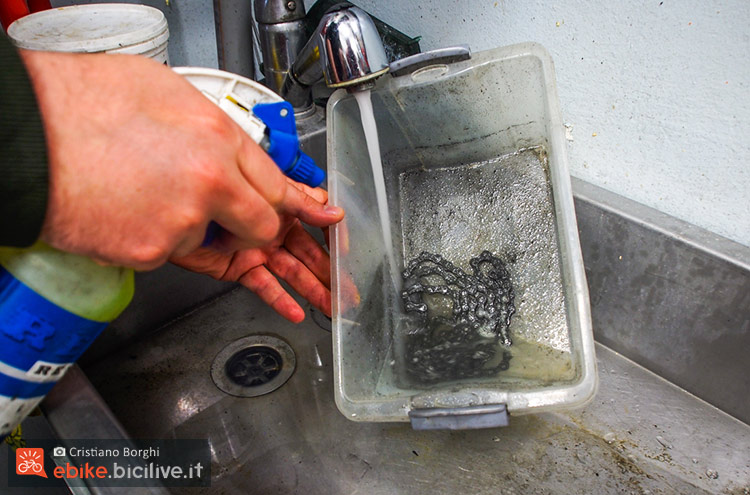 foto di Una vaschetta di plastica, acqua e un prodotto sgrassante per catene