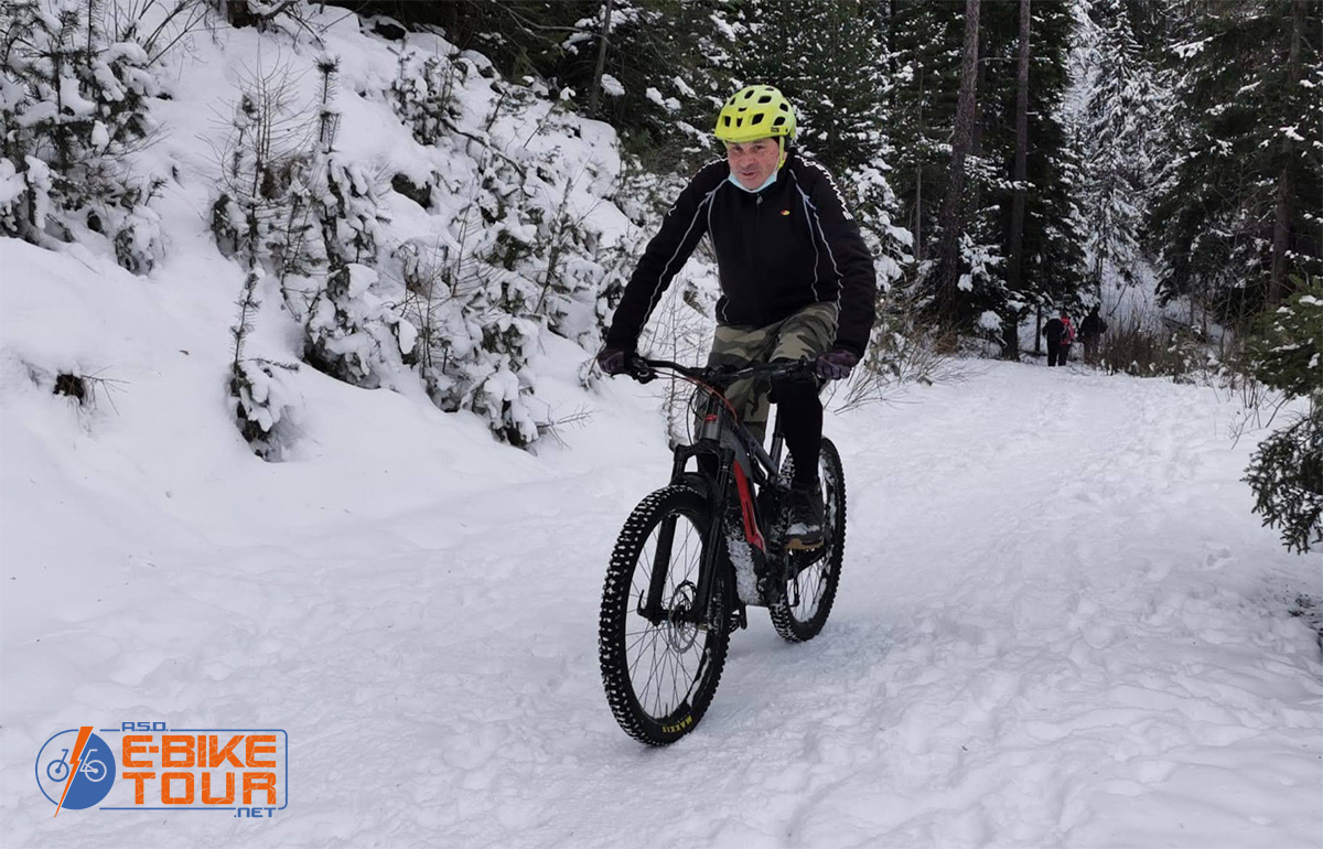 Un uomo pedala con una emtb nella neve