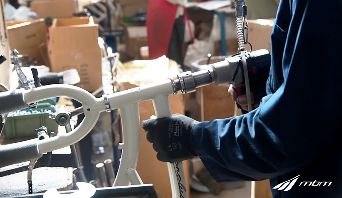 Un dipendente MBM Cicli monta un telaio in alluminio della nuova collezione