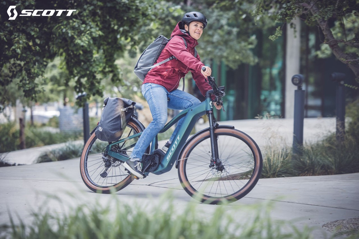 Una donna pedala in città con la nuova ebike Scott Axis E-Ride Evo 2022