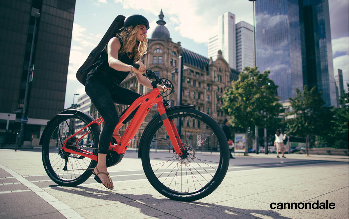 Una donna pedala in città con una nuova ebike Cannondale 2022