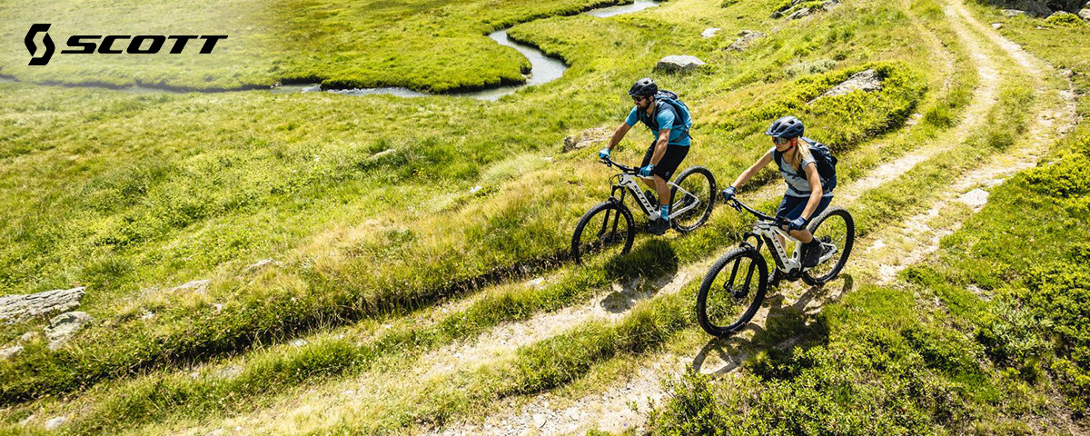 Una coppia pedala sullo sterrato con le loro nuove ebike da trekking Scott 2022