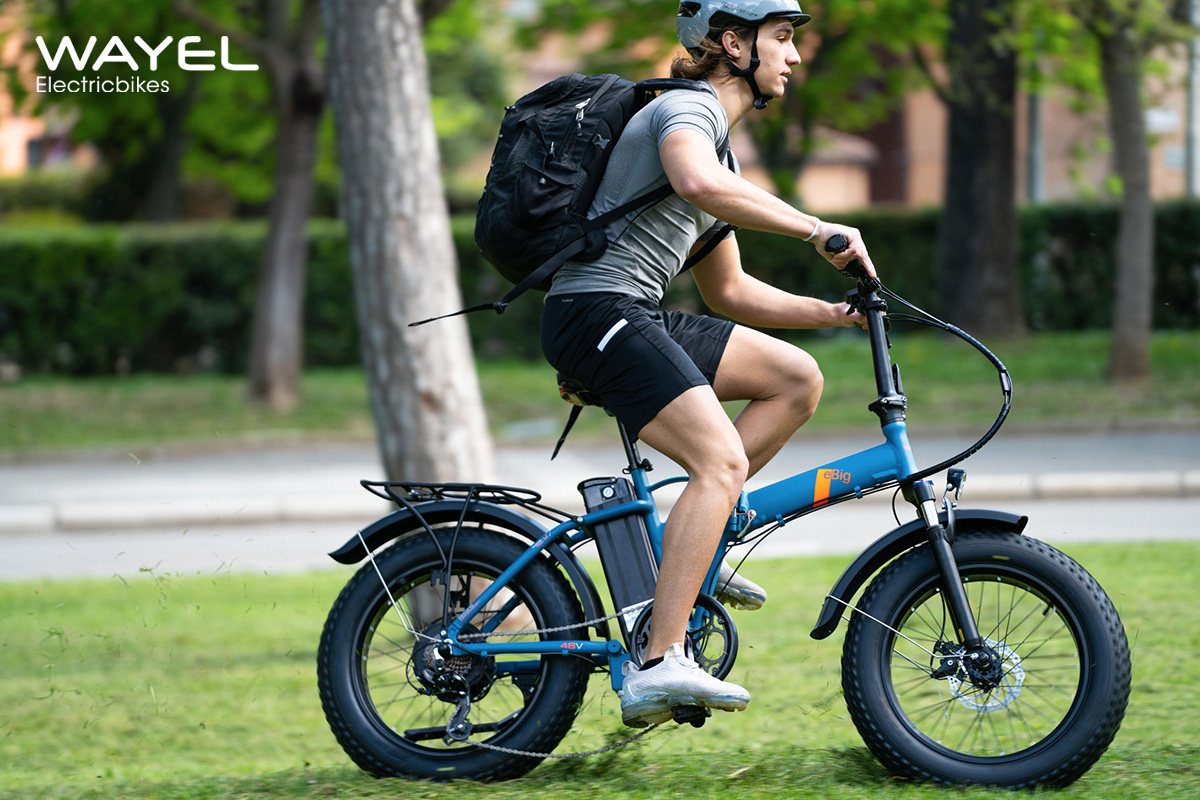 Un uomo pedala sull'erba con una nuova ebike pieghevole Wayel Ebig 2022