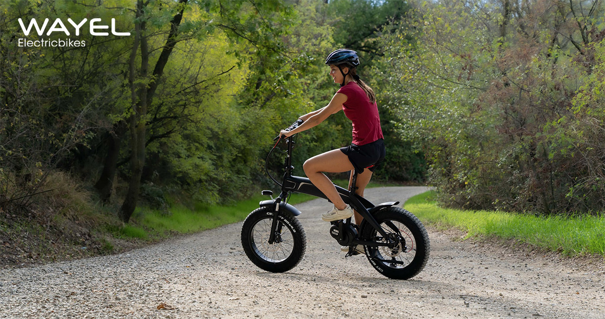 Una donna pedala sullo sterrato con la nuova ebike pieghevole Wayel Next Sport 2022
