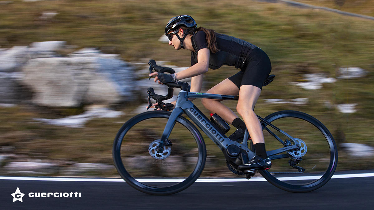 Una ciclista pedala sulla carreggiata con una nuova ebike da corsa Guerciotti Navir I.on 2022