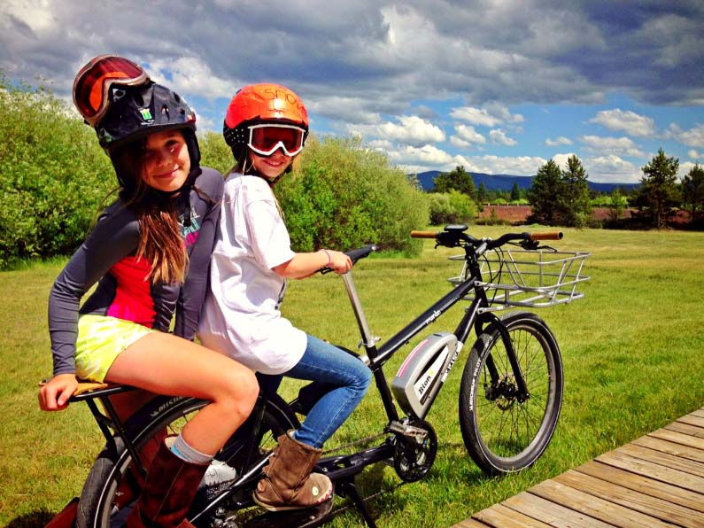 Due ragazzine in sella a una bici a pedalata assistita